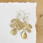 Gold toned leaf hanging from a gold toned hook.