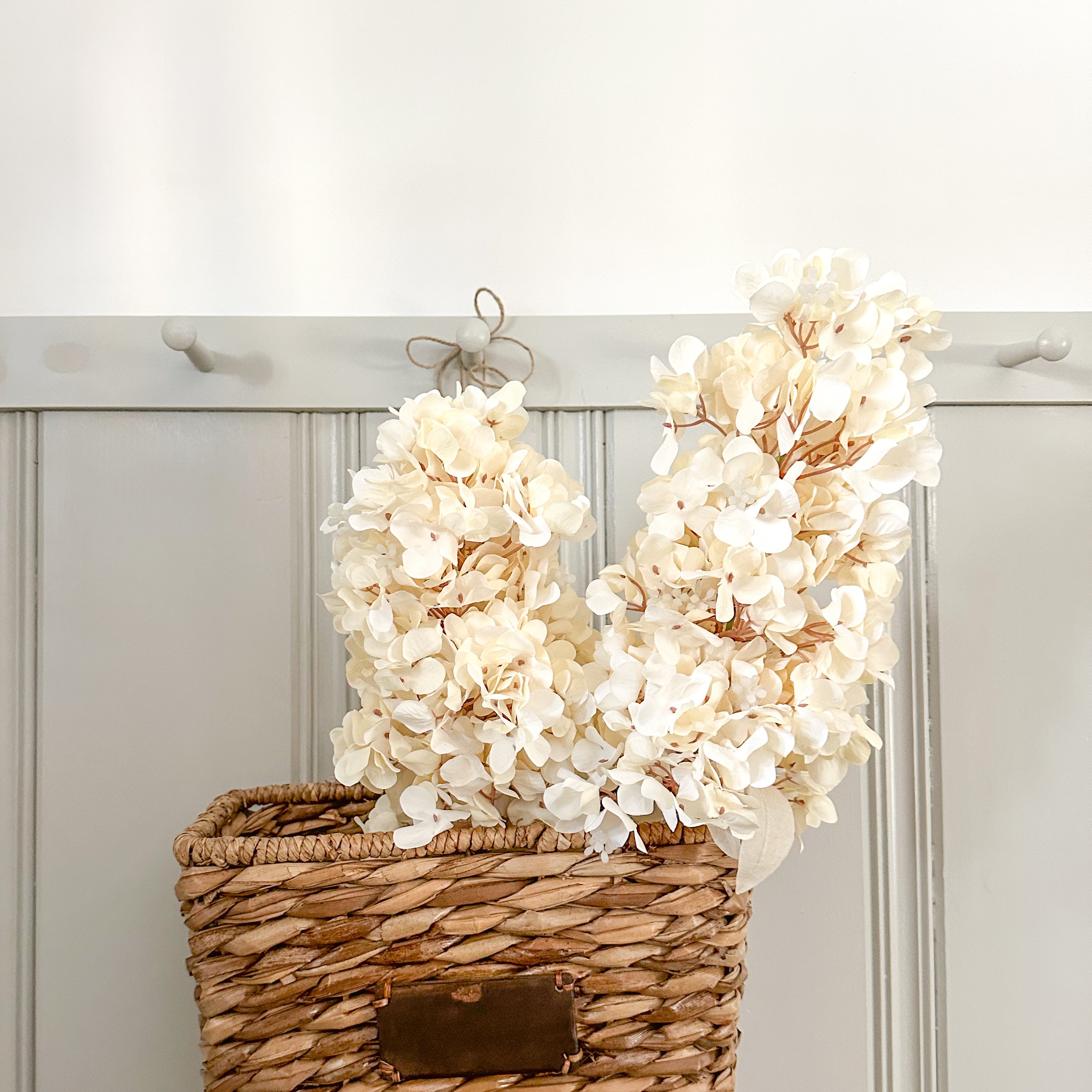 Cream Hydrangea Faux Floral Stems in Water Hyacinth Wall Basket