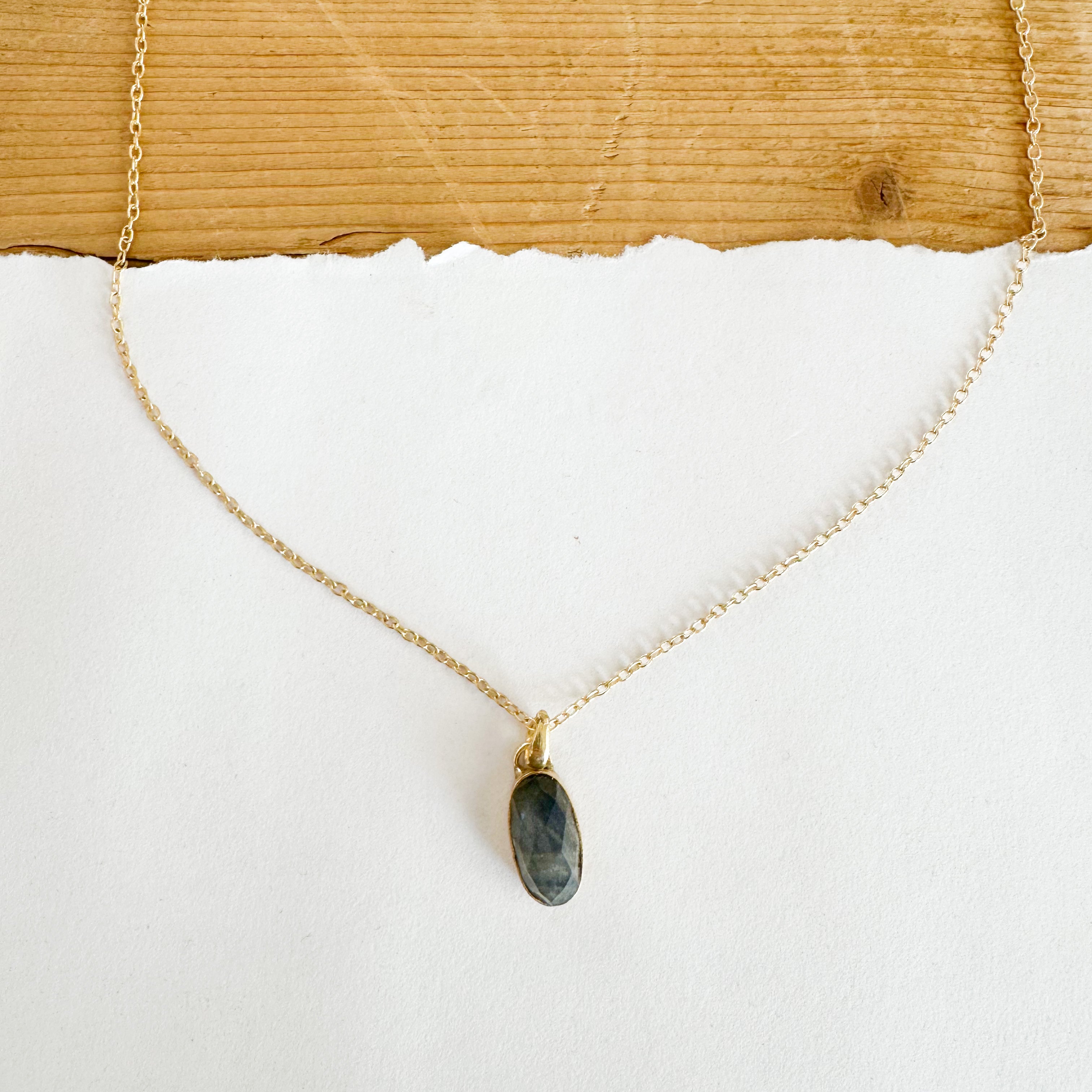 Gold tone chain necklace featuring a labradorite pendant.